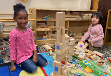 Two students playing with wooden blocks